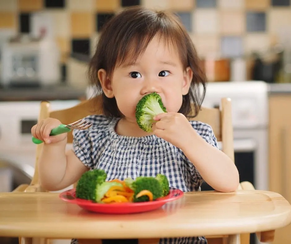 Toddler eating vegetables.
